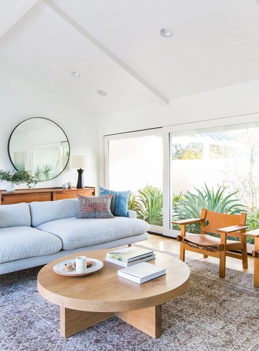 Midcentury modern gray couch living room idea in white space with round coffee table