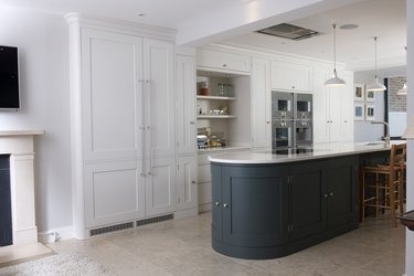 white kitchen with curved green kitchen island