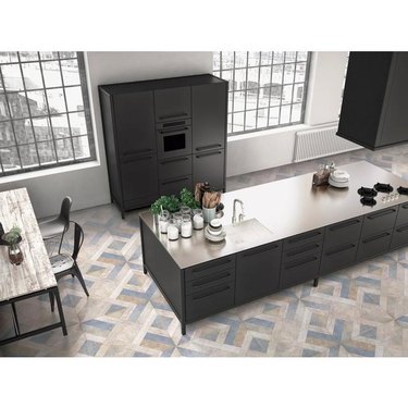 Patterned ceramic tile in modern kitchen with large island with charcoal-colored cabinets