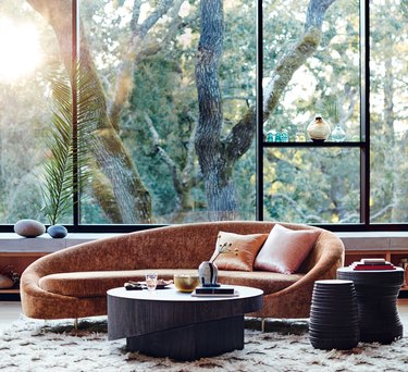 living room with large glass windows and curving velvet couch