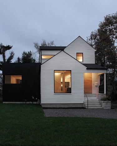 Scandinavian style house in black and white near trees