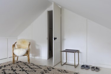 an open closet door in a white room with a shag area rug