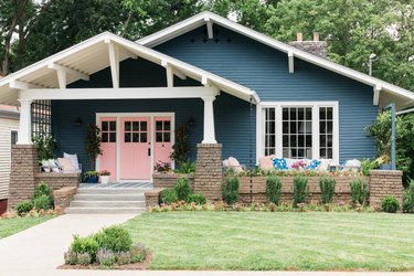 pink Craftsman-style door paired with blue exterior siding
