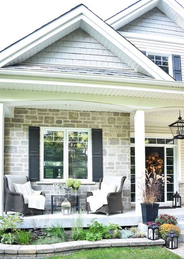 Craftsman front porch with brick exterior and wicker furniture