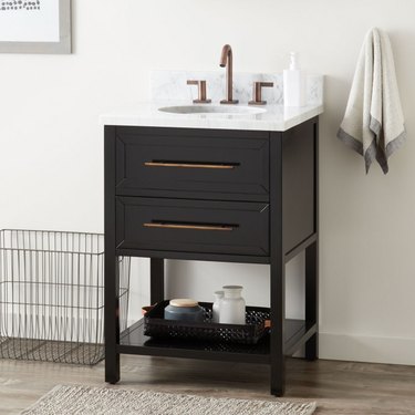 Black small bathroom vanity with large drawer pulls and quartz countertop