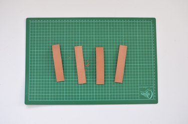 Green cutting mate with 4 identical strips of leather.