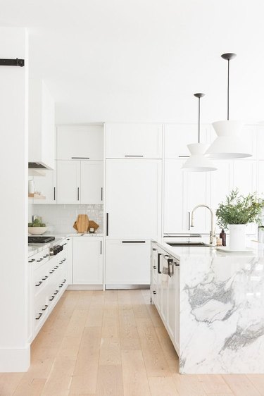 White kitchen with black hardware and wooden flooring