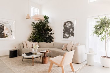 light living room with curved couch, high white walls, pendant lights