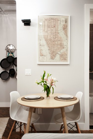 dining table near wall with framed map