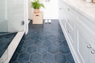 bathroom with hexagonal blue tiles, white cabinetry