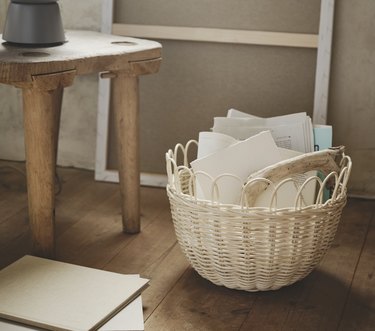 woven basket with papers on hardwood floor