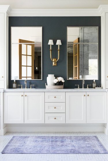 White Bathroom Cabinet with navy blue accent wall by Studio McGee