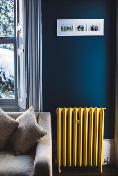 living room with yellow radiator and dark blue walls