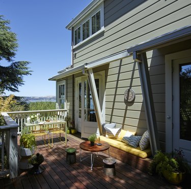 Sausalito farmhouse in green with wood deck and outdoor seating