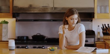 woman and google Home device in kitchen space