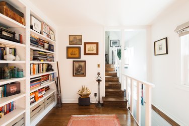built-in bookcase filled with books and gallery wall near staircase