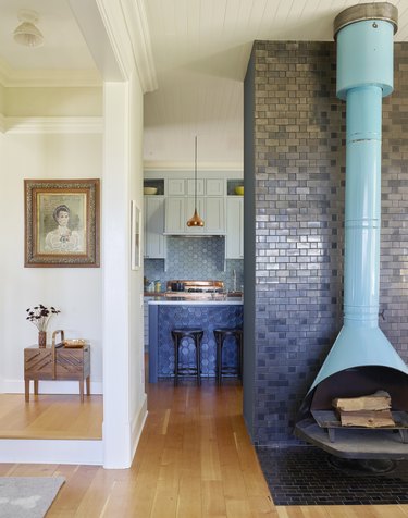 FireHOOD fireplace against black Heath tile with kitchen in the background