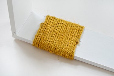 Yellow sisal rope wrapped around white wood