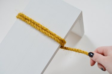 Yellow sisal rope wrapped around white wood