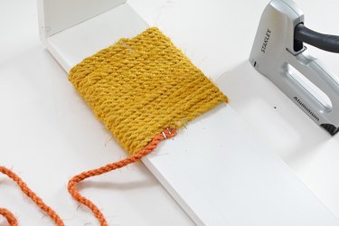 Yellow and orange sisal rope wrapped around white wood