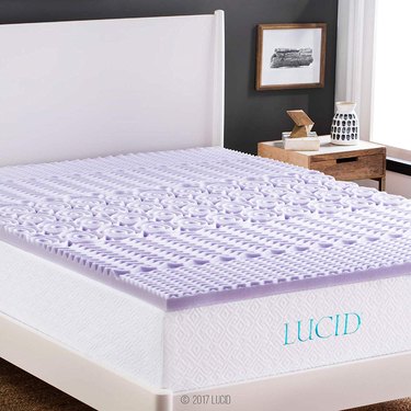 white bed with purple mattress topper