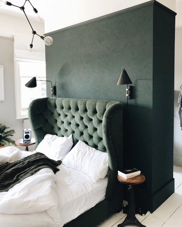 green tone-on-tone bedroom with tufted wingback headboard