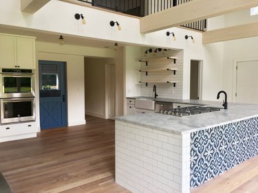 Kitchen island back panel idea with patterned tile by Dichotomy Interiors