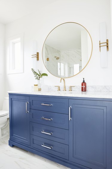 glamorous blue bathroom cabinets with white countertop and brass fixtures