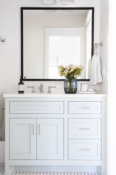 light blue bathroom cabinets with silver hardware and white countertop