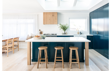 teal kitchen island with wooden stools