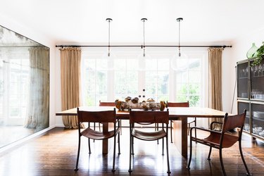 sunny dining room with glass pendant lights over wood dining table