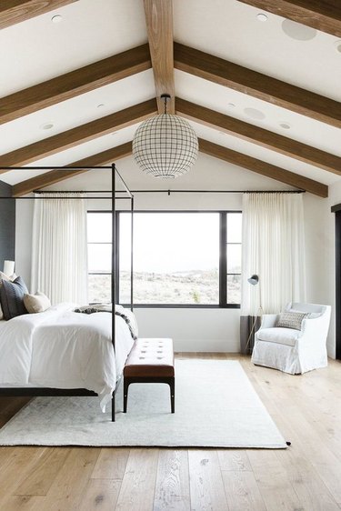 rustic bedroom with chandelier and exposed wood beams