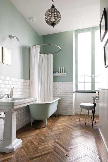 green bathroom idea with herringbone wood flooring