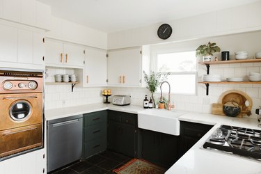 u-shaped kitchen with black lower cabinets, white countertop, subway tile backsplash