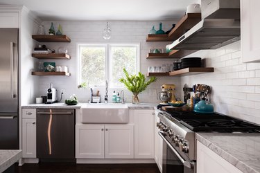 kitchen with stainless steel appliances, white cabinetry, subway tile backsplash, exposed upper shelving