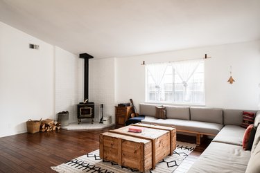 open living room with stove in the corner, hardwood floors, sectional couch