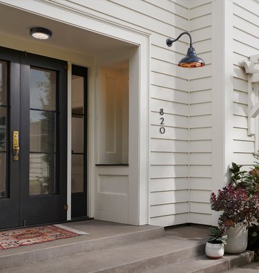 farmhouse style exterior with black glass doors and shiplap wall