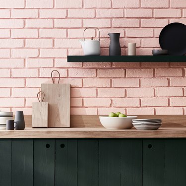 pink brick backsplash with wood countertop and open shelving