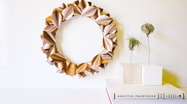 Rosegold wreath hanging on wall next to air plants.