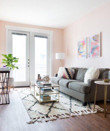 pink living room with gray sofa and white accents