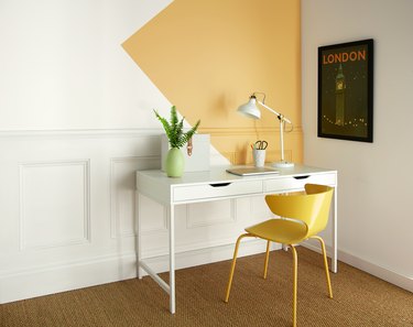 desk area with yellow chair and yellow and white wall