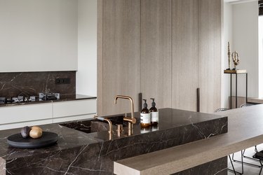 kitchen with dark marble backsplash and wood cabinetry