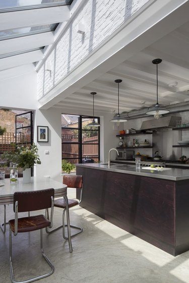 Stainless steel counters, cement floors and exposed ductwork in this industrial style kitchen