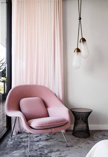 living room with pink lounge chair and drapery