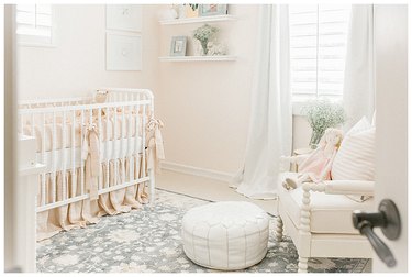vintage blush pink nursery idea with traditional style crib and floating shelving