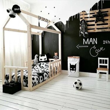 kids' bedroom idea with black chalkboard paint and house-shaped bed frame