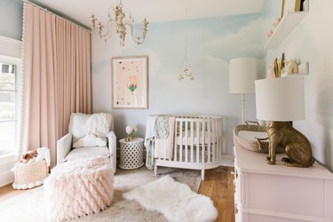 pink and blue baby nursery idea with floor to ceiling drapery and white crib