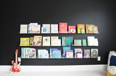 kids' bedroom idea with black walls and picture ledges displaying books