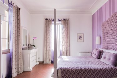 bedroom with brown tile floor and lavender walls
