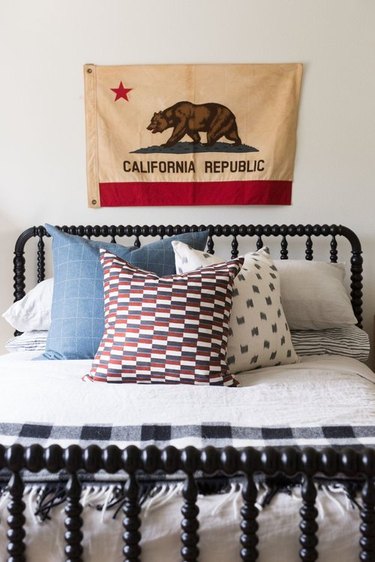 Cali cool teen bedroom idea for girls with vintage flag on wall and black bed frame